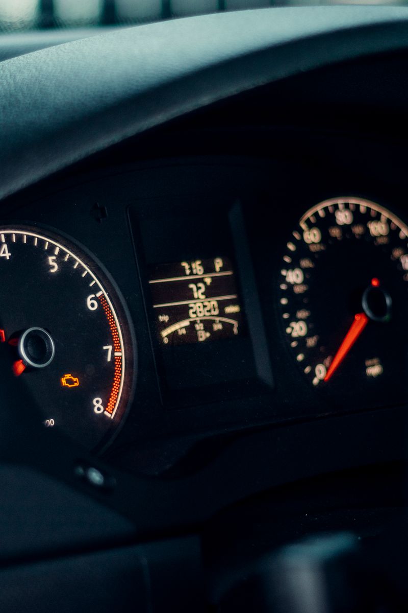 Detailed view of a car's dashboard featuring illuminated gauges and speedometer.